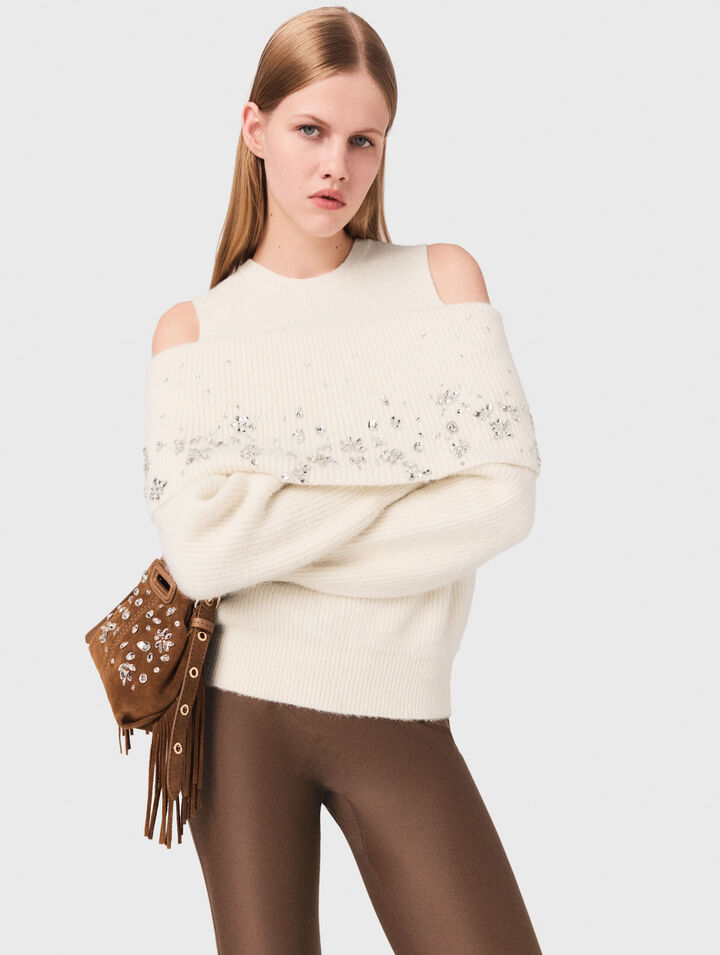 Pullover con spalle scoperte e gioielli