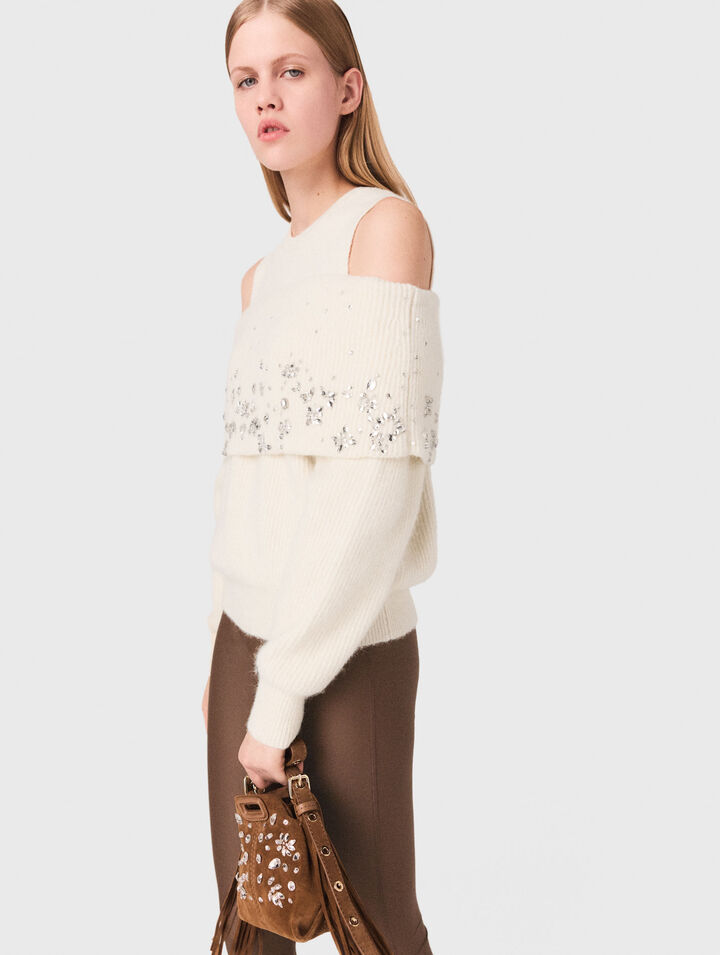 Pullover con spalle scoperte e gioielli