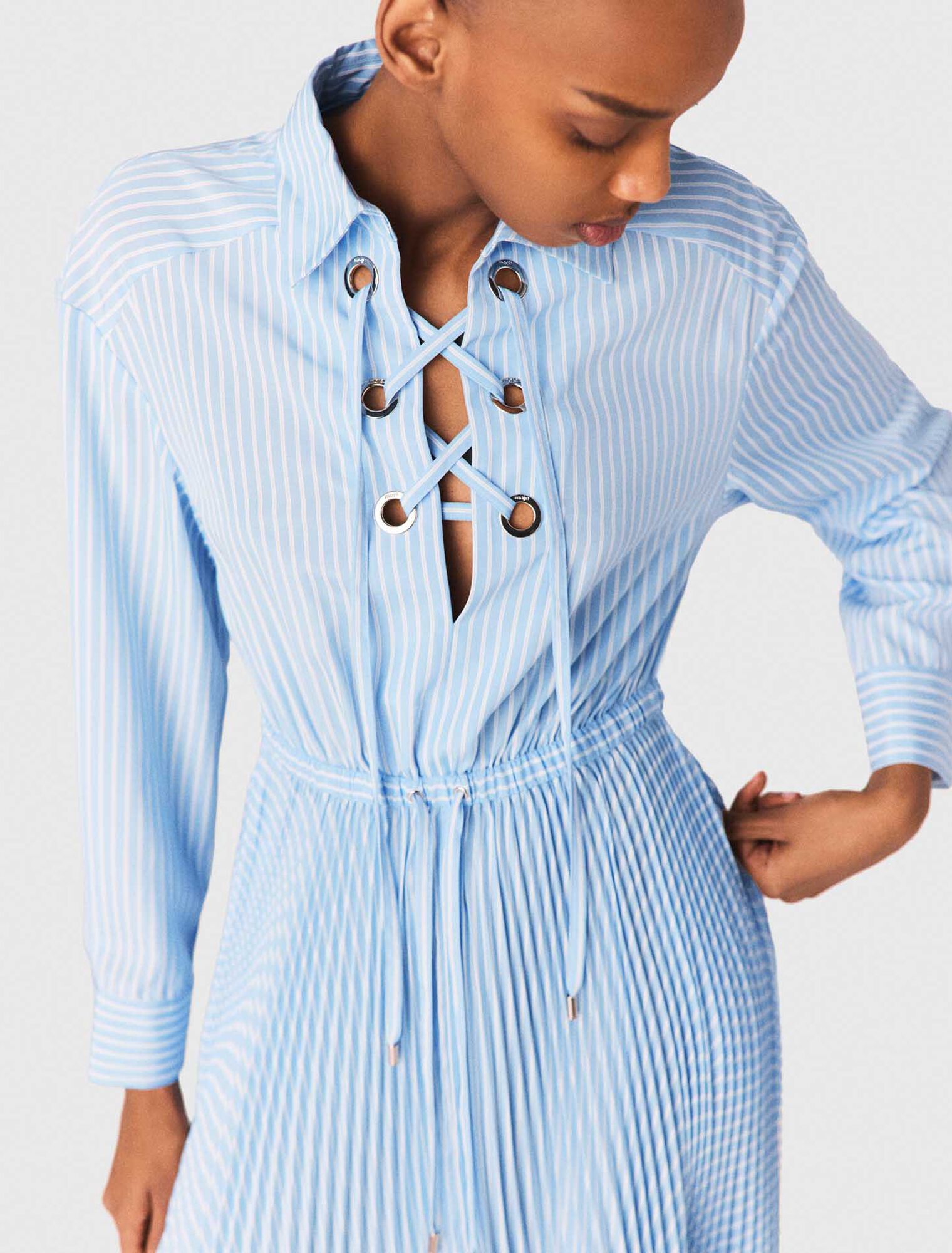 Abito lungo pliss&eacute; con occhielli