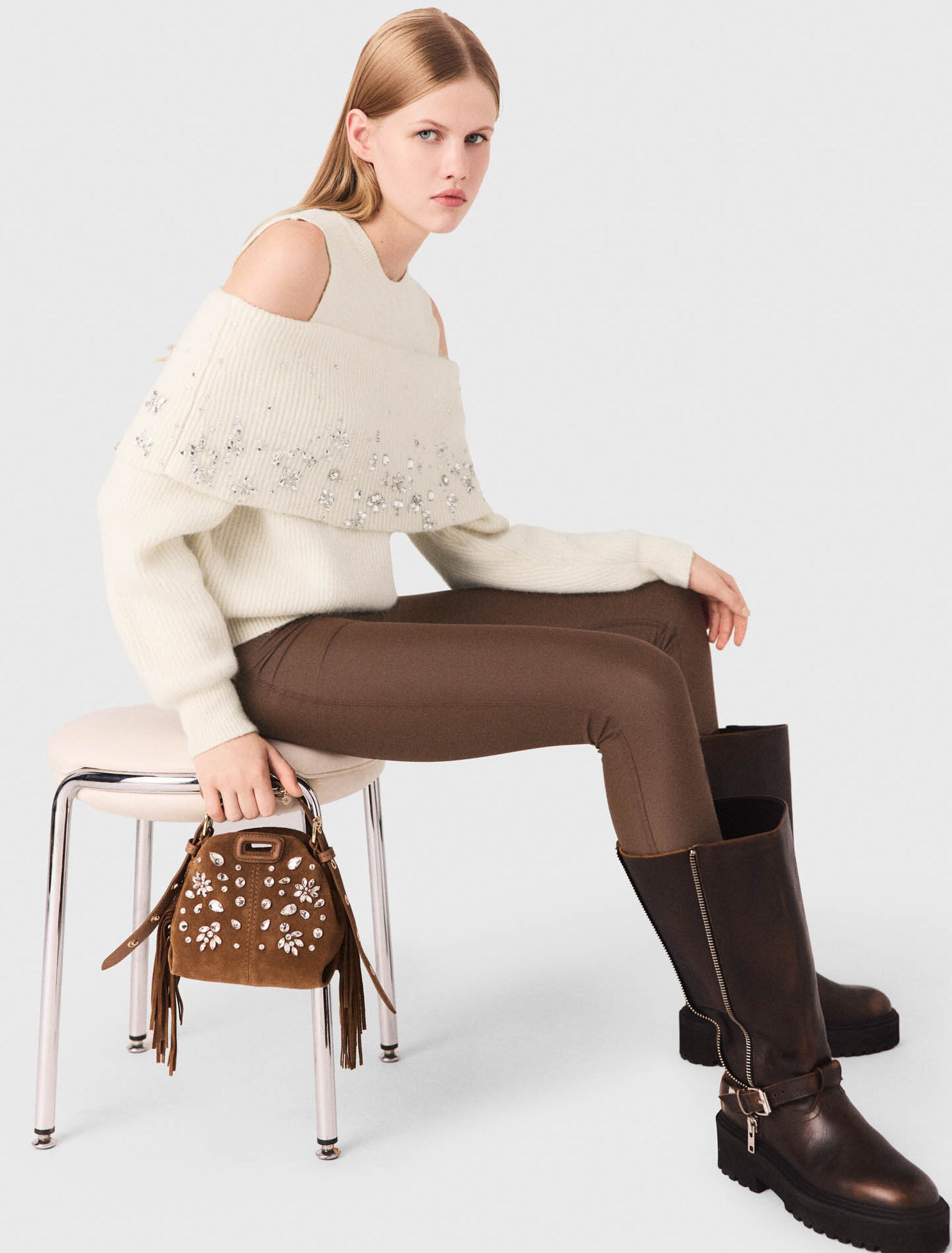 Pullover con spalle scoperte e gioielli