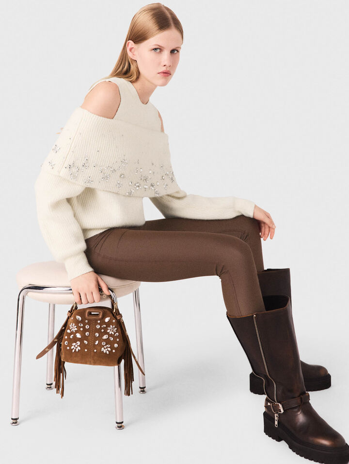 Pullover con spalle scoperte e gioielli